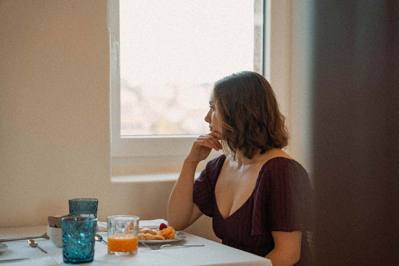 Marina Owens mirando por una ventana durante un desayuno